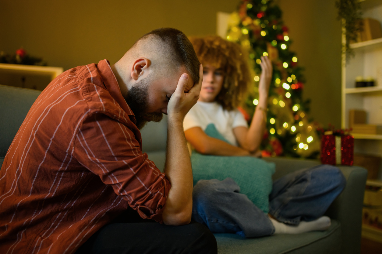 Young man feeling depressed during christmas time with partner Your Year-End Divorce Prep Checklist