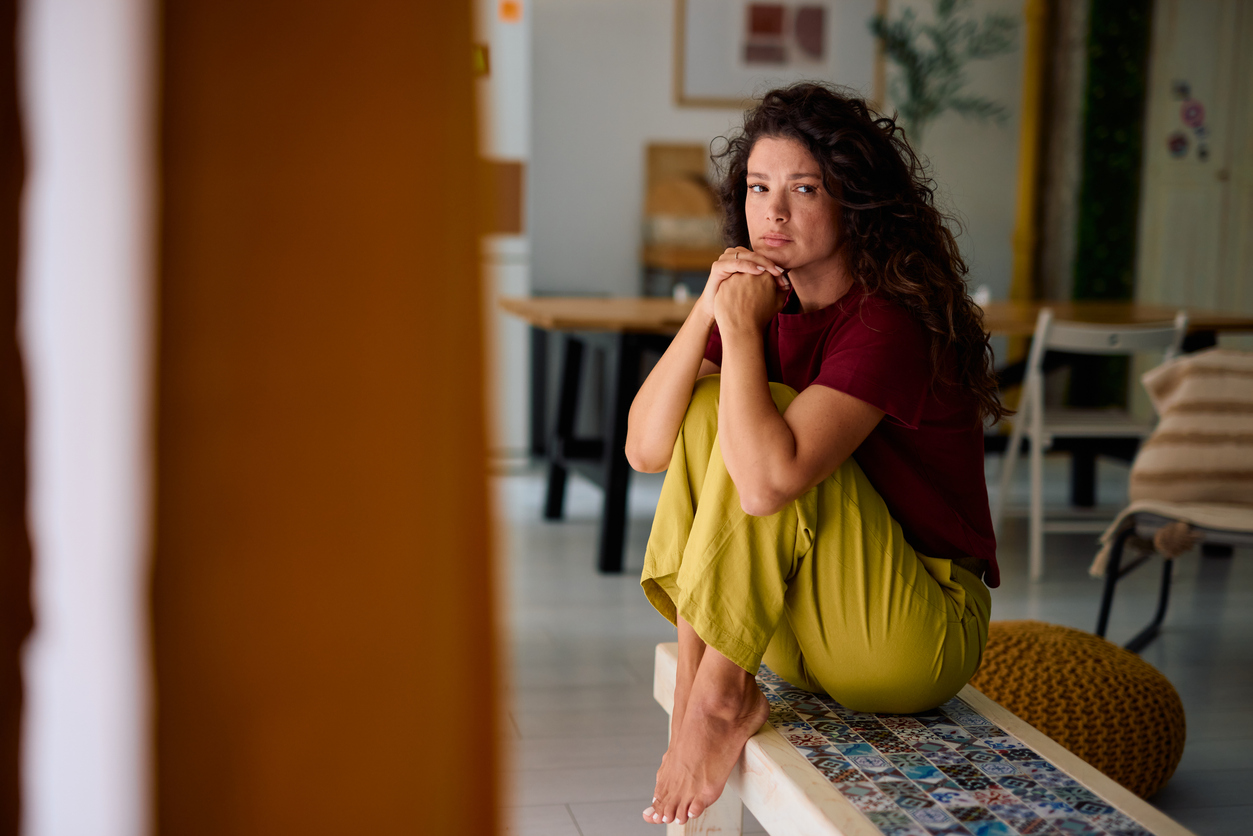 Lonely woman sitting on a bench at home feeling sad You Can Miss the Life Without Missing the Person: Understanding the Hidden Grief of Divorce